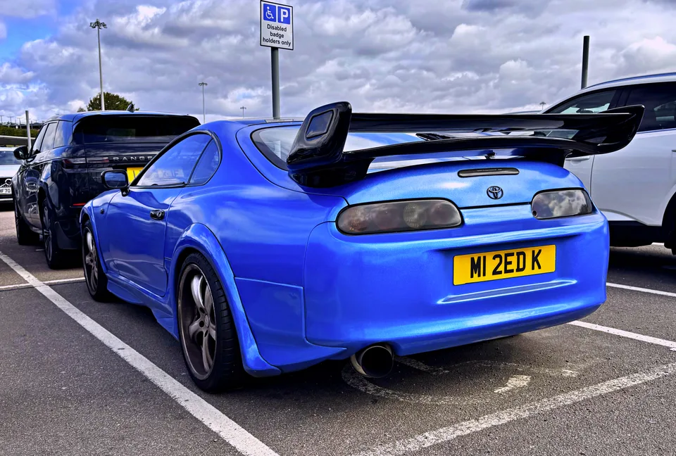 Blue Toyota Supra with a large rear wing