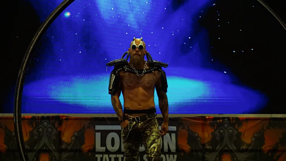Masked performer against a blue stage backdrop