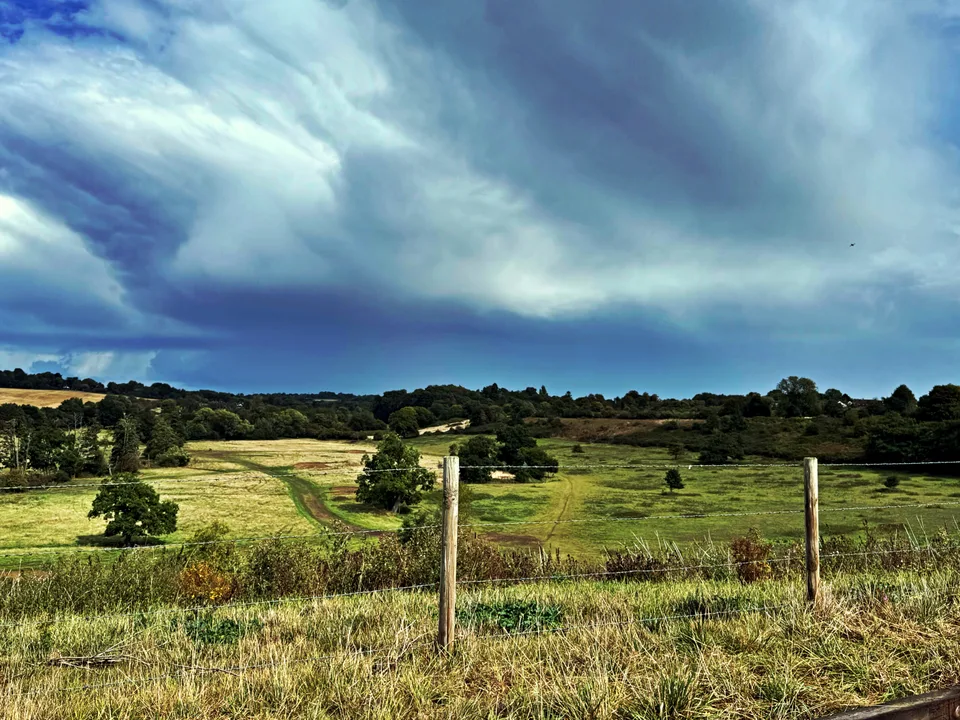 Rolling fields beneath dramatic clouds