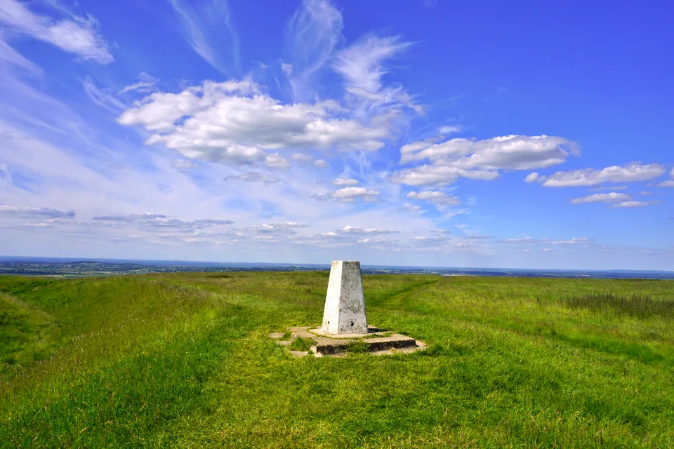 Hilltop survey marker beneath a wide blue sky