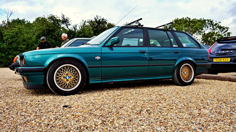 Green BMW estate with gold wheels